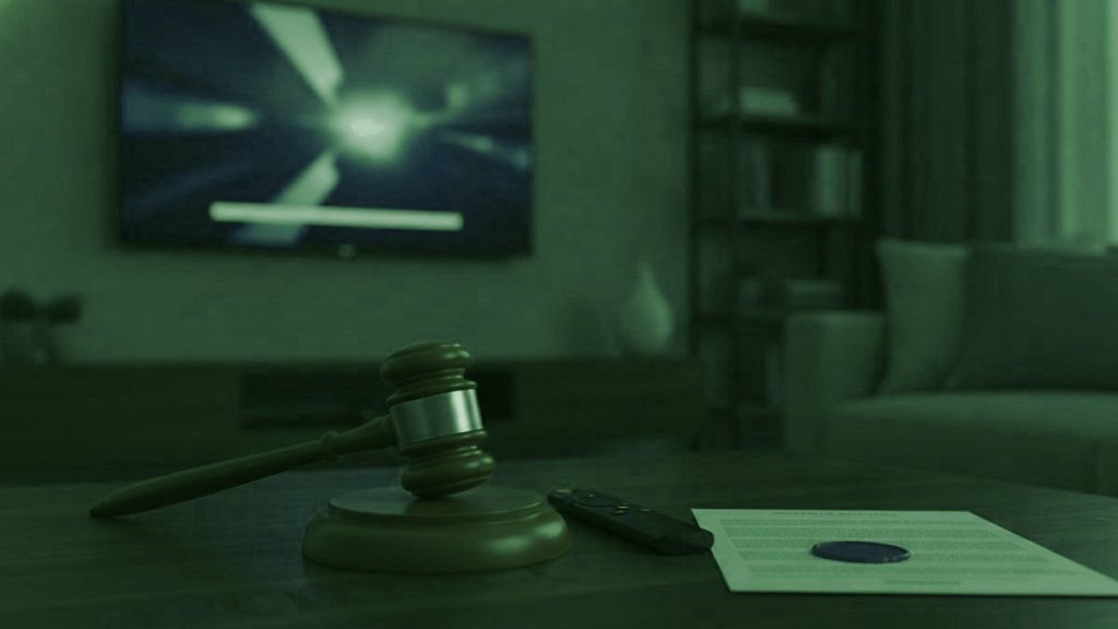 A judge gavel, a streaming remote and a sealed document on a coffee table in front of a TV